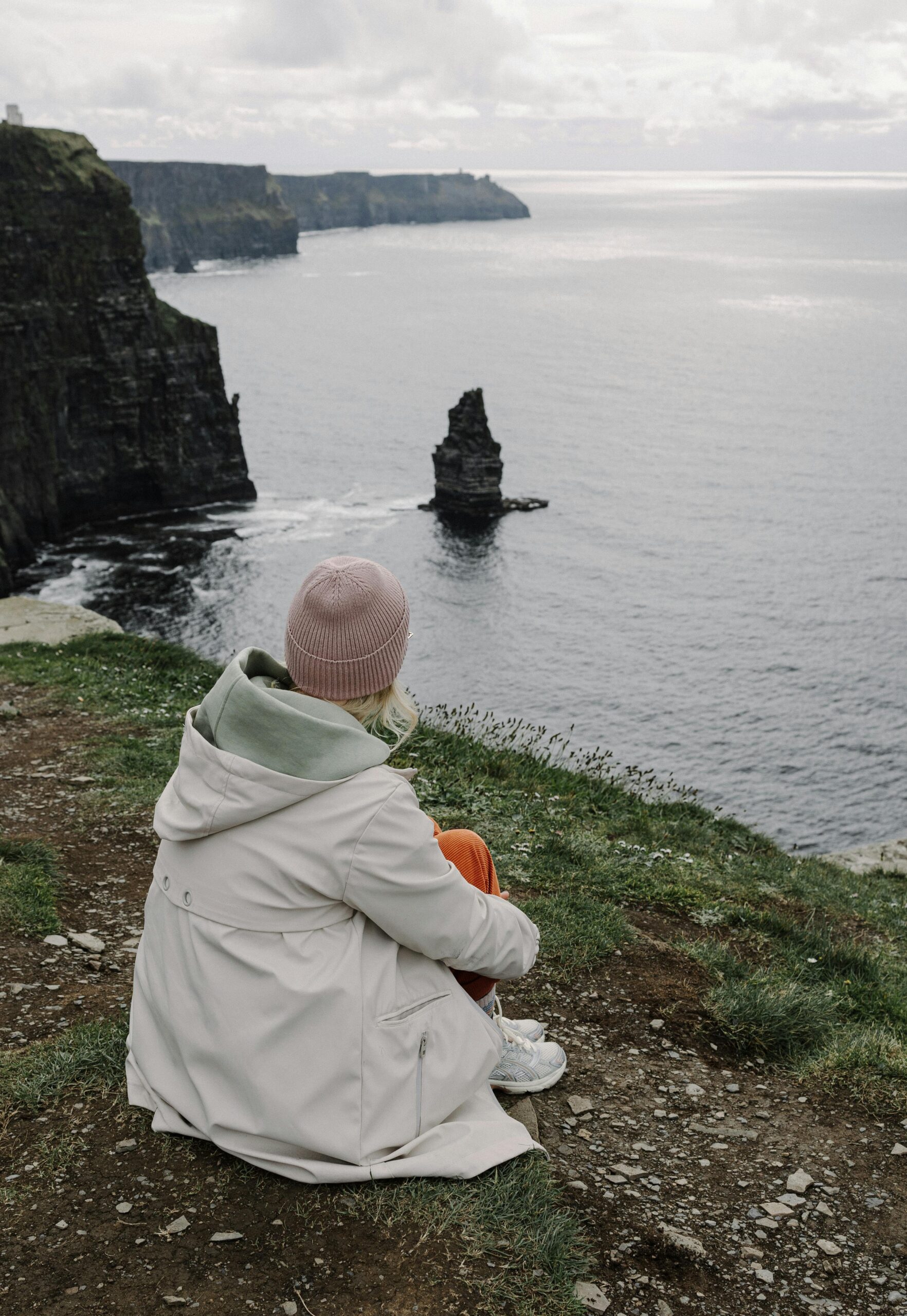 A woman sitting by the sea in quiet reflection — Deerstone retreat